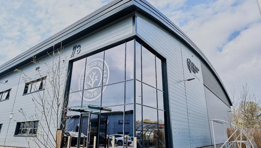 Modern building with glass facade and WVH logo, under a blue sky with clouds